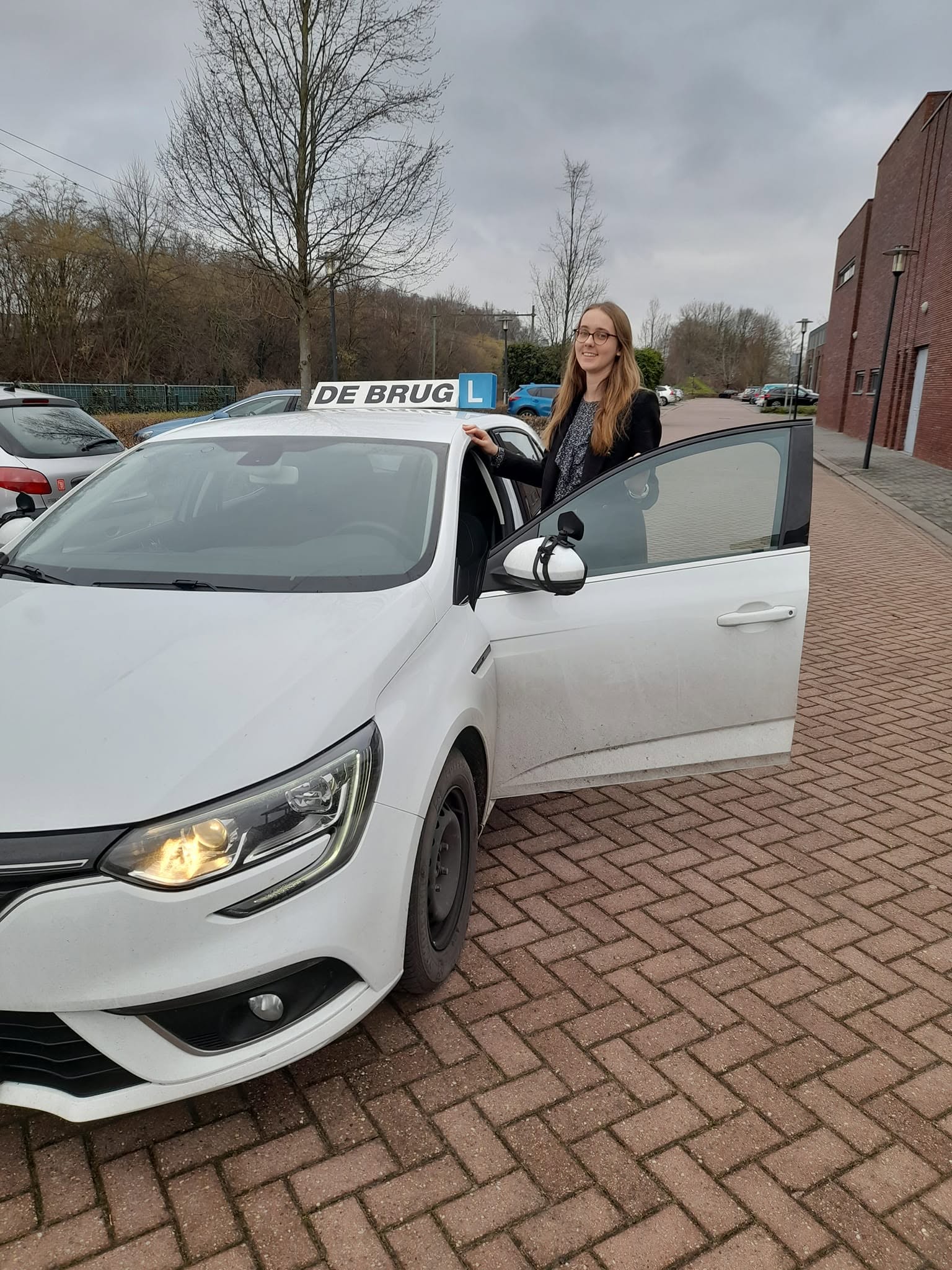 Geslaagde leerlinge bij de lesauto van Autorijschool De Brug