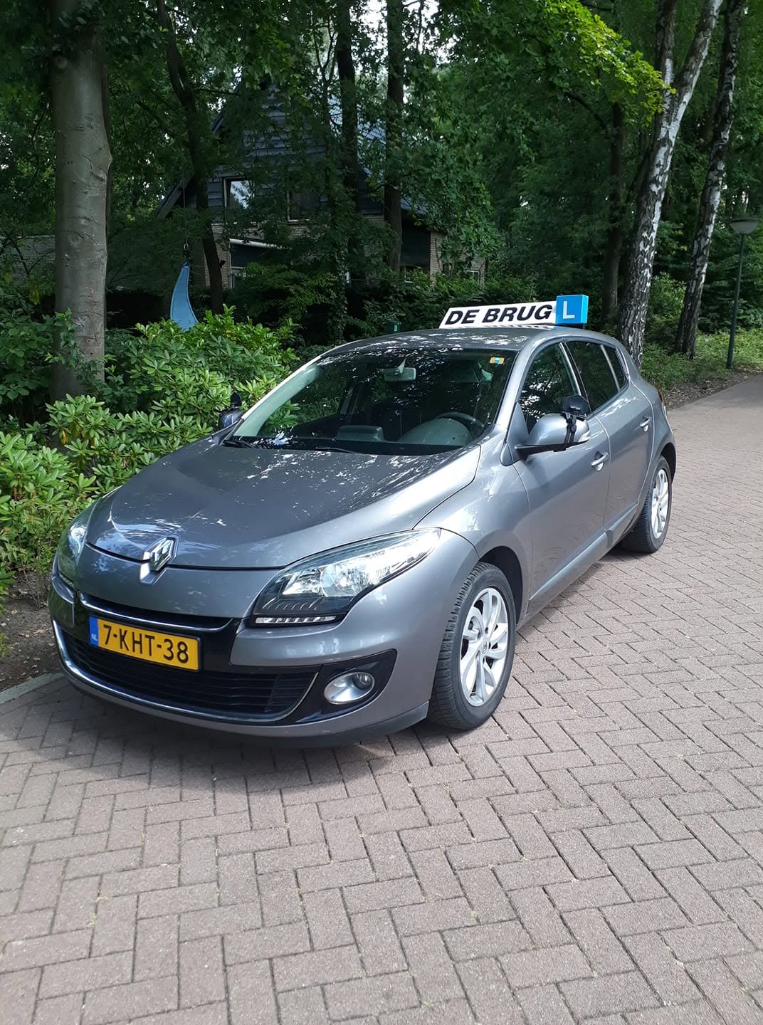 De lesauto van Autorijschool De Brug met het kenmerkende De Brug-dakschild